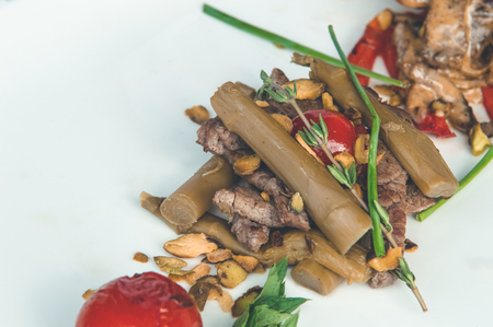 Close up of a delicious meal with baked vegetables and sauce in a white plate.の写真素材