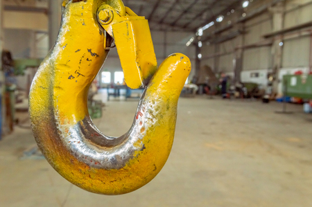 Closeup of a industrial yellow lifting crane hook in a factory.の写真素材