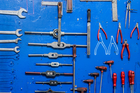 Working tools on blue painted wooden board in a factory storage room.の写真素材
