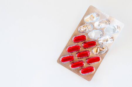 Top view of  red capsules on white background. Medication concept.