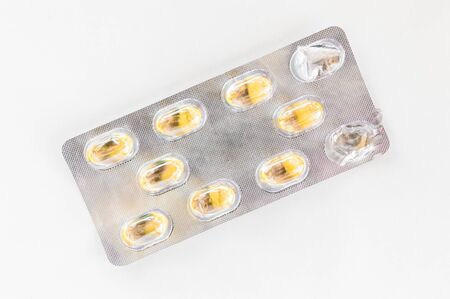 Top view of  yellow capsules on white background. Medication concept.
