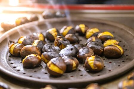 Close up of roasted chestnuts for sale on the street in winter. Street food concept.の写真素材