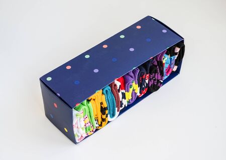 Blue carton box with neatly folded colorful socks. Minimalist lifestyle, declutter and sorting...