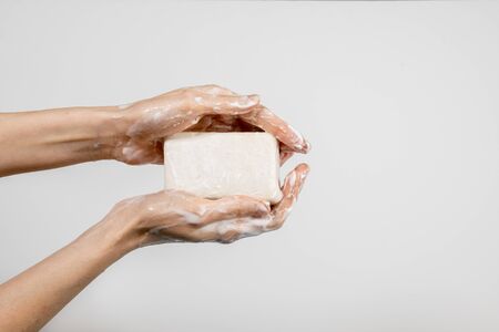 Close up of Caucasian woman washing her hands with bubbly soap bar isolated on white background. Demonstration of hand washing. Concept of hygiene and prevention coronavirus.の写真素材