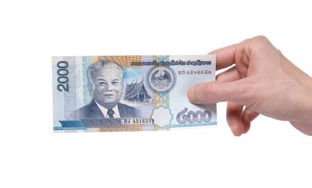 Female hand holding a 2000 Kip banknote currency isolated on a white background. President Kaysone Phomevihane portrait on the money.の写真素材