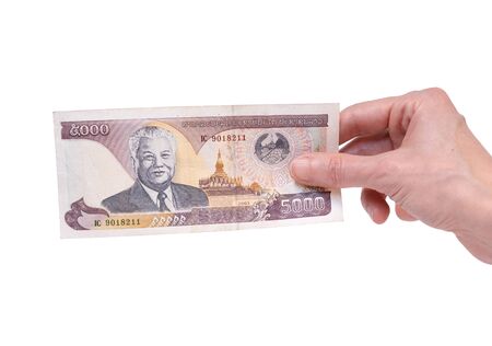 Female hand holding a 5000 Kip banknote currency isolated on a white background. President Kaysone Phomevihane portrait on the money.の写真素材