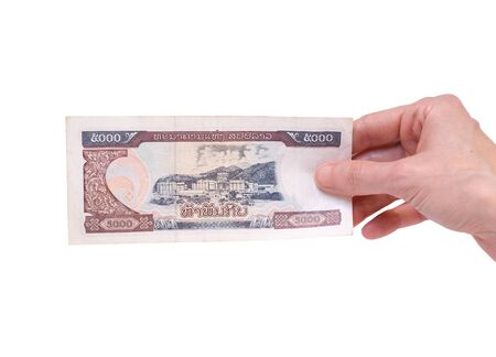 Female hand holding a 5000 Kip banknote currency isolated on a white background. Denomination of 5000 Kips.の写真素材