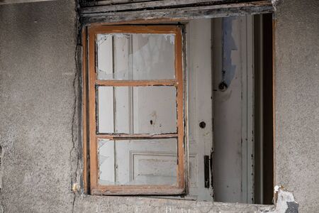 Windows of an abandoned building with wooden frames and broken glasses.の写真素材