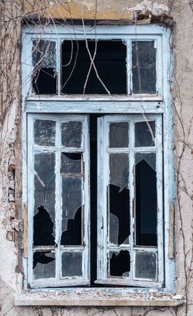 Windows of an abandoned building with wooden frames and broken glasses.の写真素材