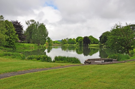 Park and pond with cloudy skyの写真素材