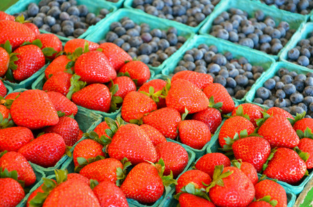 Baskets of fresh red strawberries and blueberries