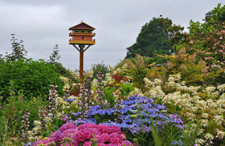 Birdhouse overlooking colorful spring gardenの写真素材