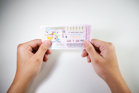 2 hands holding lottery ticket. Waiting list. Thailand, Asiaの写真素材