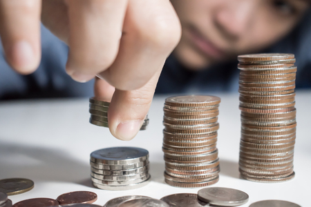 Asian man wearing a blue shirt is counting on his money. Saving money conceptの写真素材