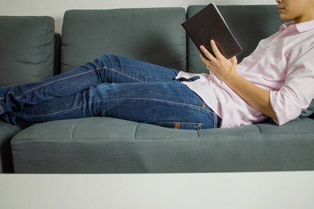 People are reading book on the sofa. Close up.の写真素材