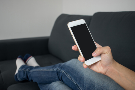 Close up. People are playing the phone on the sofa.の写真素材
