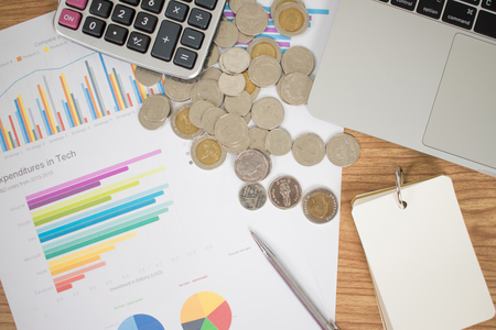 Top view of the desk with coins, graphs, calculator and pen.の写真素材