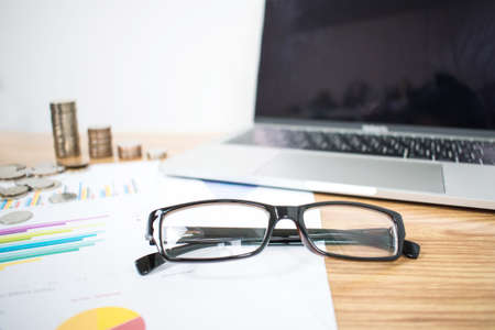 The eyeglasses of a business on a wooden table in a business concept.の写真素材