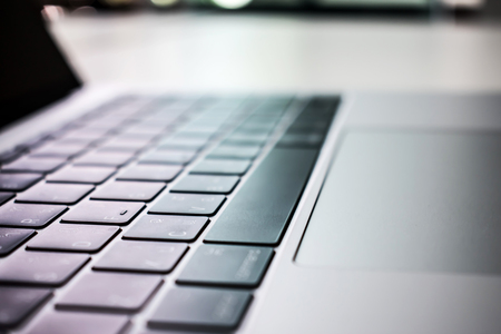 Close up. Computer keyboard on a white desk by the window.の写真素材