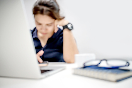 Blurred photo. Businessmen are working in a white room. And she is in serious contact. Asia.の写真素材