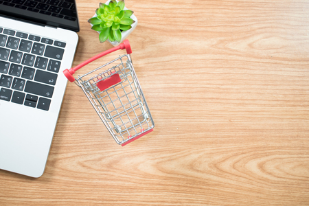 Photo Top view of a shopping cart, a computer on a table of businessmen. Business Concepts.の写真素材
