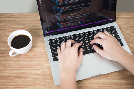 Web development, close-up images, a woman writing a program on a laptop screen.