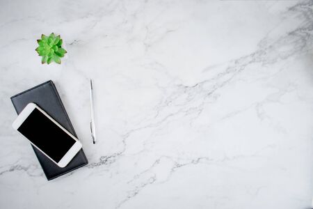 Top view of smartphone on leather bag And plant pots on modern office desks with copy space, flat...