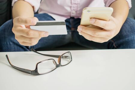 Shopping online with credit cards on smartphones in the room.
