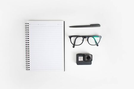 Top view of arrangement of notebooks, glasses, pen and camera. Isolated background.の写真素材