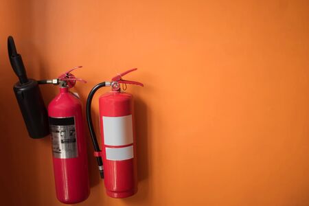 Fire Extinguisher on the orange wall.の写真素材