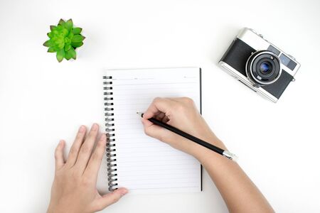 Flat lay of hand drawing of a notebook, film camera, and a plant pot on a white desk. Top view.の写真素材