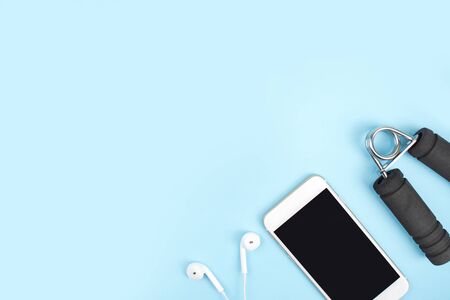 Top view. Sports accessories with dumbbells, smartphones, headphones in a blue background. With copy space.の写真素材