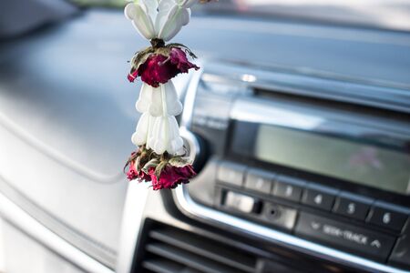 Dried garland, dried roses left in the car. Close-up.の写真素材