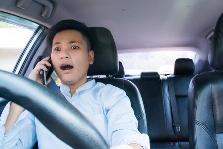The Asian people on the leather seats feel shock from using a smartphone in the car. Travel concept.