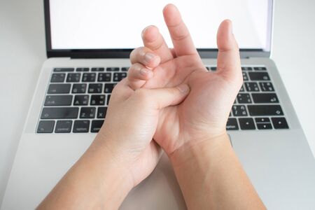 Hand pain of women with office syndrome from working on computers.の写真素材