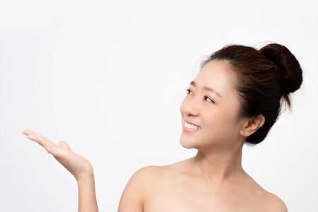Closeup of Asian skin of a young woman on a white background in the studio. She is using hand to present.の写真素材