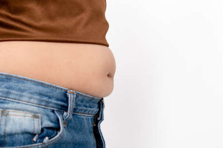 Asian women are overweight on a white background in the studio. Belly liposuction concept.の写真素材