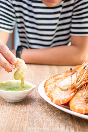 Top corner of freshly baked shrimp served on a plate with sauces, onions, garlic and chilies.の写真素材