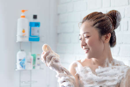 Beautiful woman taking shower in her bathroom. She is very happy.
