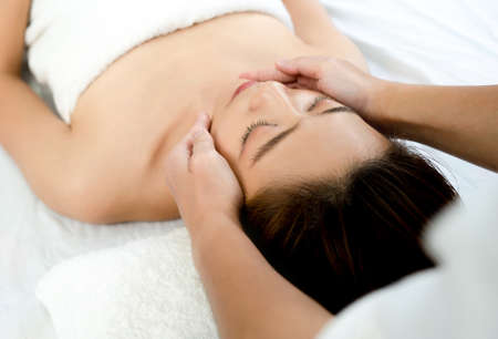 Closeup face of a beautiful Asian woman to face massage in the spa. Beauty health concept.の写真素材