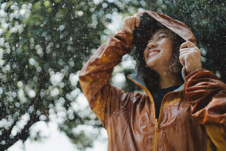 Hand close-up of an Asian woman wearing a raincoat at the outdoors.の写真素材