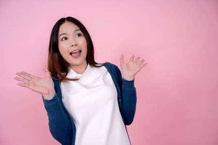 Asian girls are surprised and excited. On pink background in the studio.の写真素材