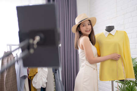 Asian women selling fashionable clothes are online on social media. She smiled for the camera.の写真素材