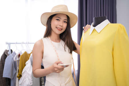 Beautiful Asian women sell fashion clothes on social media online.