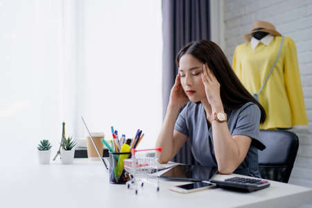 Young Asian woman online selling fashion clothes She has a headache