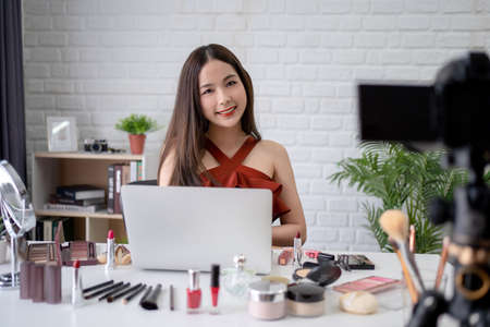 Professional makeup blogger and beautiful Asian woman are recording makeup tutorials to share on...