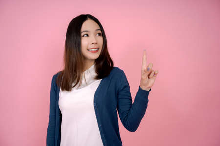 Asian beautiful woman and finger pointing on pink background.の写真素材