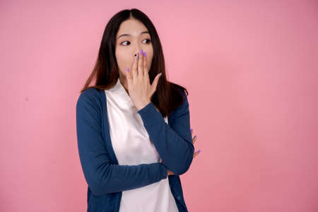 Asian woman is shocked She is covering her mouth with her hand with a copy space.の写真素材