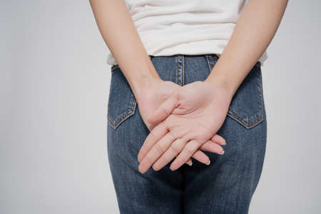 Asian woman has diarrhea holding her bum, pain in the butt, isolated on white background.の写真素材