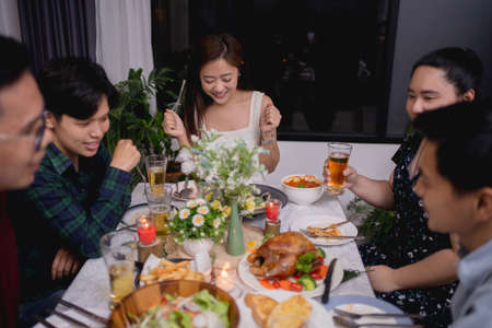 Group of Asian people were at a party and eating at home. They exchange ideas with each other.の写真素材